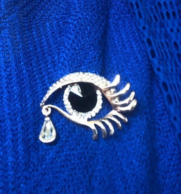 Eye with teardrop pin on a blue dress (600 x 643)
