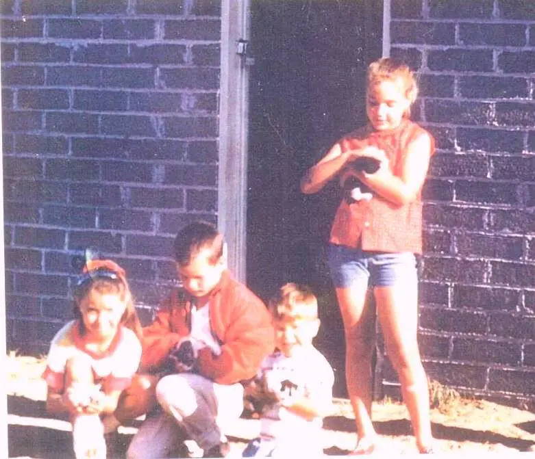 Debbe at age 8 (on the far right) helping an abandoned kitten