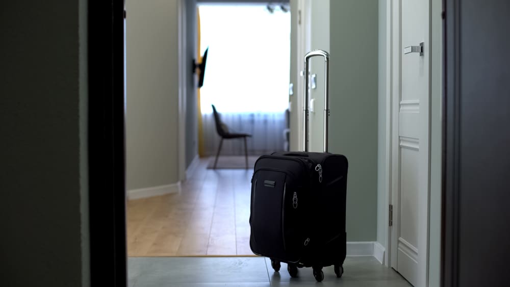 Door,Opened,To,Room,With,Suitcase,In,Middle,,Check,Into