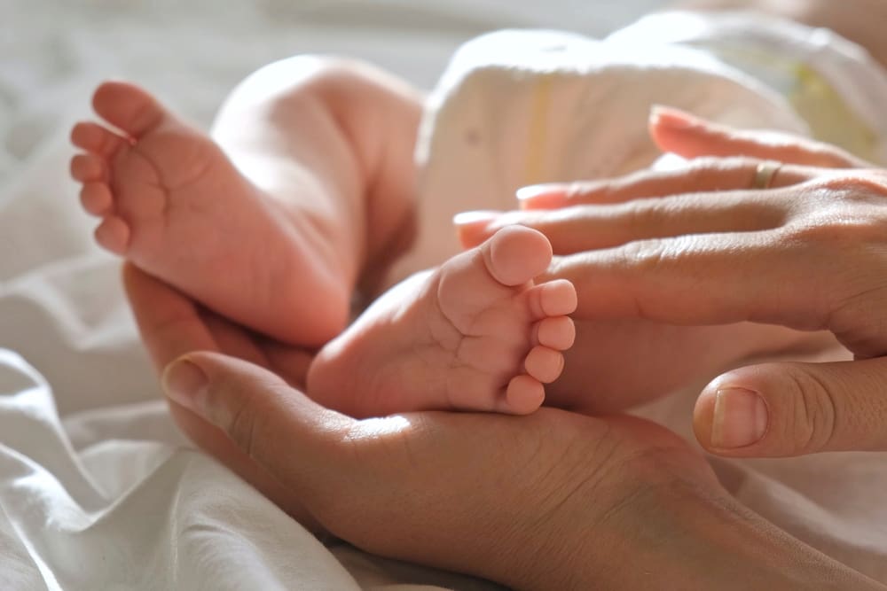 Baby,Feet,In,Mother,Hands,,On,Her,Palm.,Happy,Parents